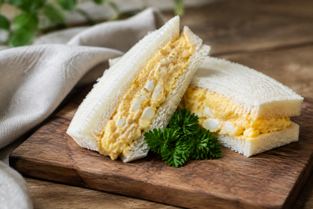 Close-up of a Japanese Tamago Sando sandwich with fluffy egg filling in soft natural light